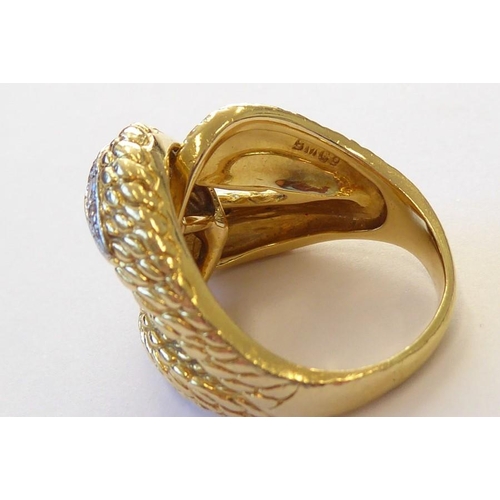 313 - An early 1970s 18 carat yellow gold and diamond-set dress ring, the textured double knot design set ... 