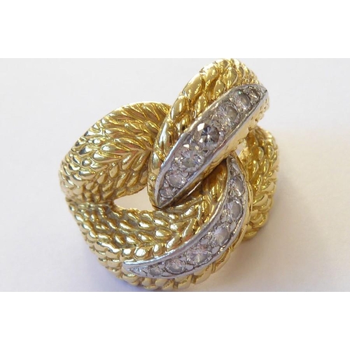 313 - An early 1970s 18 carat yellow gold and diamond-set dress ring, the textured double knot design set ... 