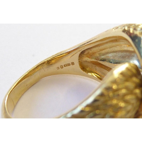 313 - An early 1970s 18 carat yellow gold and diamond-set dress ring, the textured double knot design set ... 