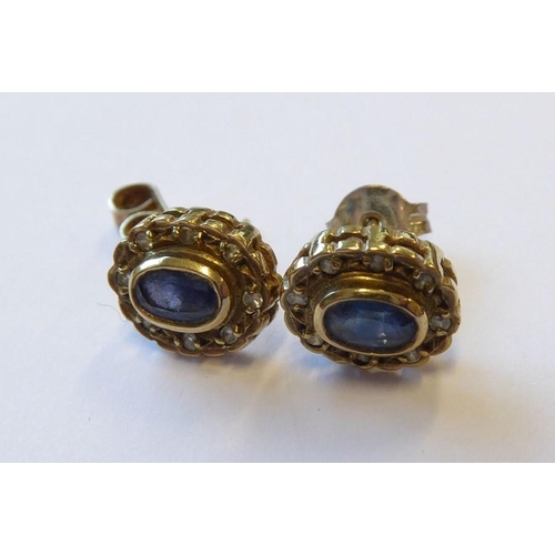 325 - A pair of sapphire and diamond set earrings each with oval-faceted collet-set sapphire within a sing... 