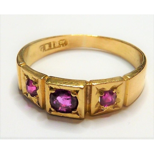 329 - An early 18-carat gold ring set with three rubies; ring size  (The cost of UK postage via Royal Mail... 