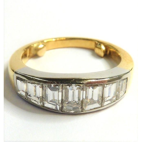 337 - A seven-stone diamond ring; the graduated emerald-cut diamonds set in a line to the plain bi-coloure... 