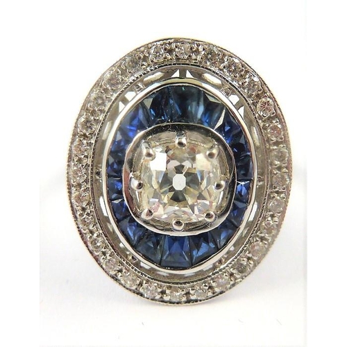 338 - An 18-carat gold sapphire and diamond cluster ring of oval form, the centre diamond 1 carat, ring si... 