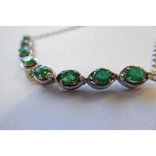 340 - An emerald and diamond set chain necklace, the front section set with eight oval-faceted claw-set em... 