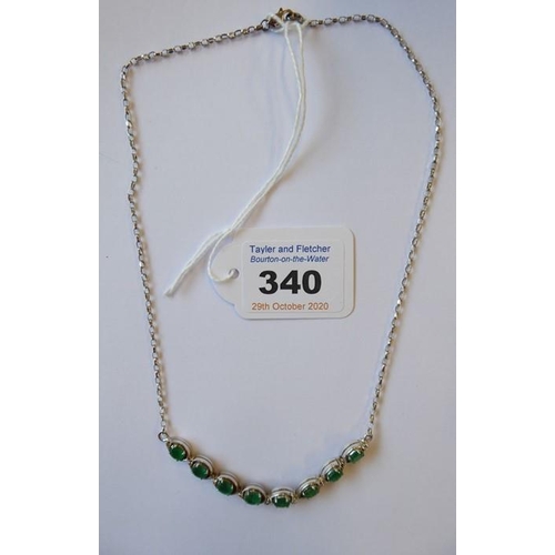 340 - An emerald and diamond set chain necklace, the front section set with eight oval-faceted claw-set em... 