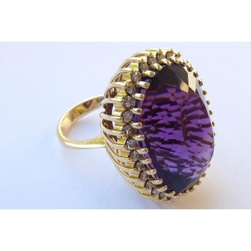 344 - An amethyst and diamond-set dress ring, the oval mixed-cut amethyst claw-set above the brilliant-cut... 