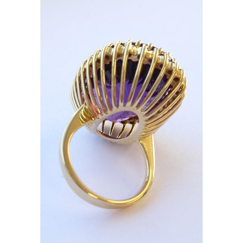 344 - An amethyst and diamond-set dress ring, the oval mixed-cut amethyst claw-set above the brilliant-cut... 