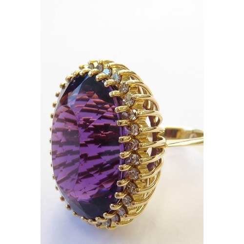 344 - An amethyst and diamond-set dress ring, the oval mixed-cut amethyst claw-set above the brilliant-cut... 