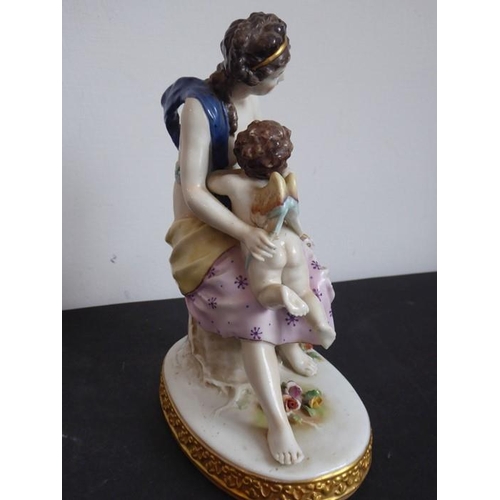 38 - A 19th century hand-decorated Naples porcelain figure model of a scantily clad maiden embracing a wi... 