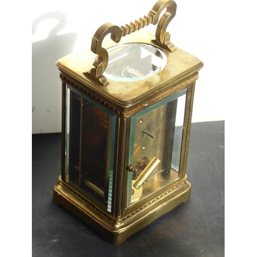 401 - An early 20th century brass carriage clock timepiece; the swing handle above an enamel dial with Rom... 