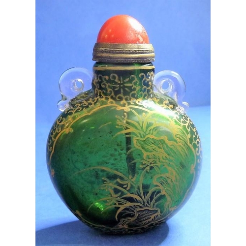 488 - An 18th century Chinese green-glass snuff bottle with gilt-metal spoon, decorated with gilt flowers ... 