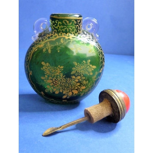 488 - An 18th century Chinese green-glass snuff bottle with gilt-metal spoon, decorated with gilt flowers ... 