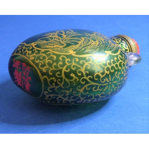 488 - An 18th century Chinese green-glass snuff bottle with gilt-metal spoon, decorated with gilt flowers ... 