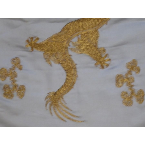 531 - A Chinese silk work wall hanging decorated with gold stitching with two dragons contesting a central... 