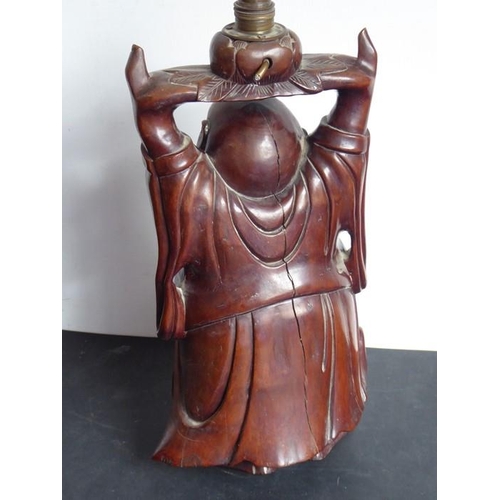 533 - A early 20th century carved Chinese hardwood lamp modelled as a standing bald corpulent figure holdi... 