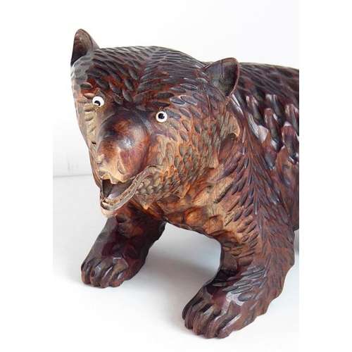 557 - A good and heavy late 19th century carved Black Forest bear; standing four square, with open mouth a... 