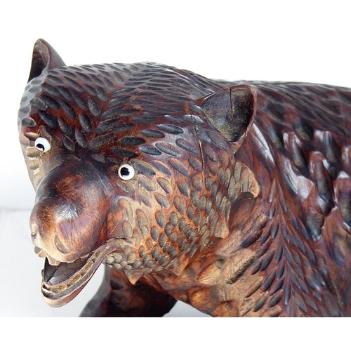 557 - A good and heavy late 19th century carved Black Forest bear; standing four square, with open mouth a... 