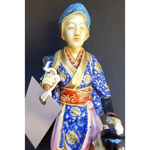 56 - A late 19th/early 20th century Japanese porcelain figure; the blue-robed female with head covering a... 