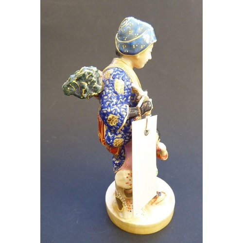 56 - A late 19th/early 20th century Japanese porcelain figure; the blue-robed female with head covering a... 