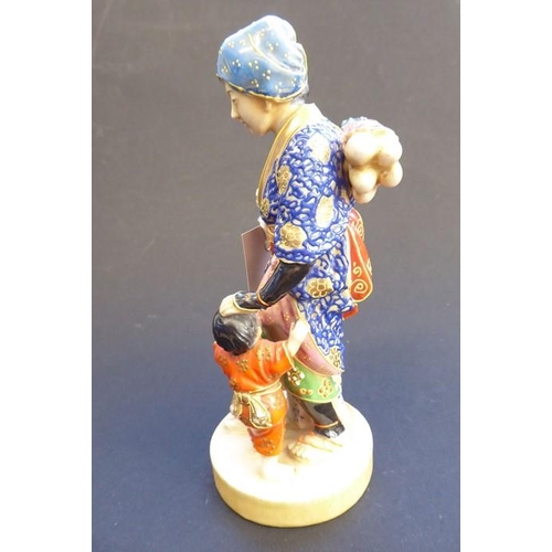 56 - A late 19th/early 20th century Japanese porcelain figure; the blue-robed female with head covering a... 