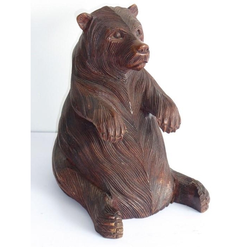 561 - A 19th century carved Black Forest bear; the corpulent animal seated and with outstretched paws (lef... 