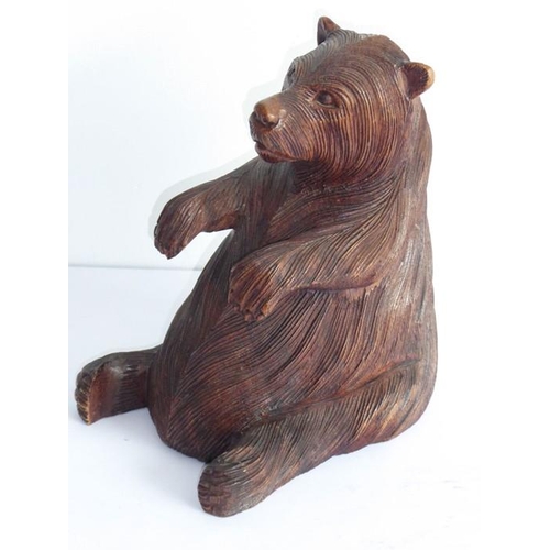 561 - A 19th century carved Black Forest bear; the corpulent animal seated and with outstretched paws (lef... 