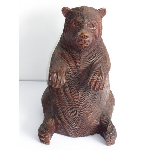 561 - A 19th century carved Black Forest bear; the corpulent animal seated and with outstretched paws (lef... 