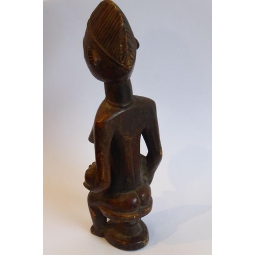 571 - A carved Congolese female figure with a babe in arms seated on a circular stool (20cm high)