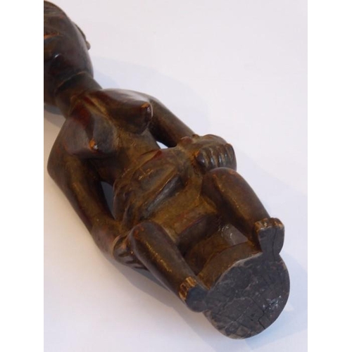 571 - A carved Congolese female figure with a babe in arms seated on a circular stool (20cm high)