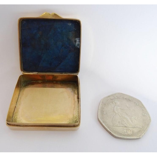 578 - A small gilt-metal snuff box; set with a rectangular lapis lazuli top (3.5cm wide)