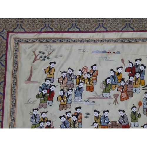 599 - A Chinese silk work finely embroidered with many figures, the central figures holding aloft and carn... 