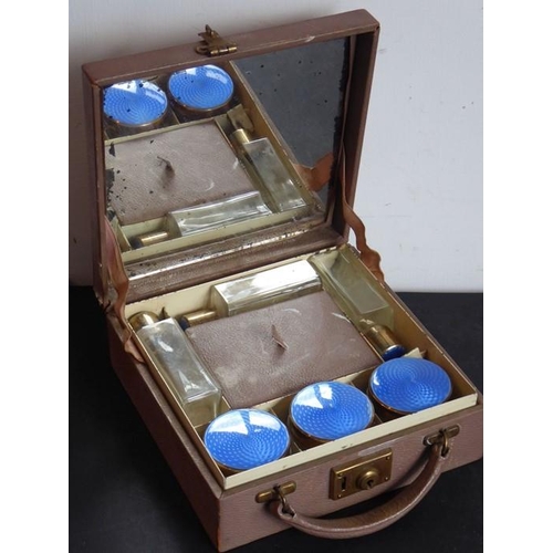 743 - An early 20th century lady's travelling vanity case containing glass bottles and three facet-cut jar... 