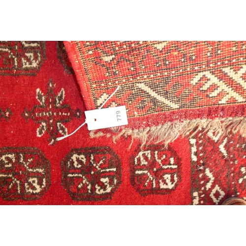 779 - A red-ground Afghan rug with 'Gul' pattern (178cm x 102cm)