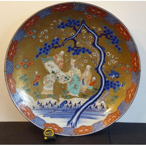 80 - An extremely large 19th century Japanese porcelain charger; centrally decorated against a gilt groun... 