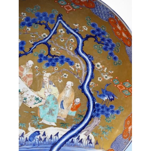 80 - An extremely large 19th century Japanese porcelain charger; centrally decorated against a gilt groun... 