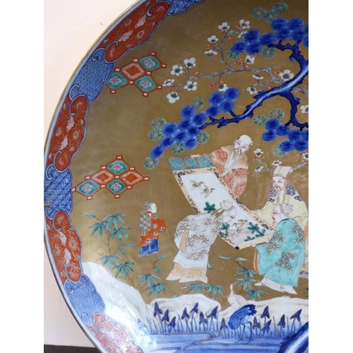 80 - An extremely large 19th century Japanese porcelain charger; centrally decorated against a gilt groun... 