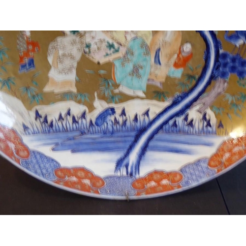 80 - An extremely large 19th century Japanese porcelain charger; centrally decorated against a gilt groun... 