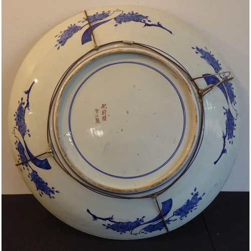 80 - An extremely large 19th century Japanese porcelain charger; centrally decorated against a gilt groun... 