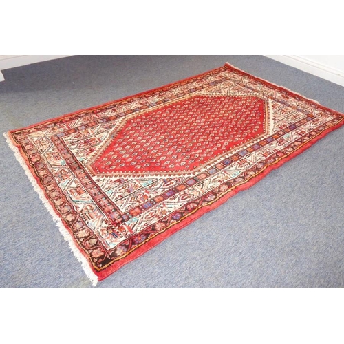 827 - A north-west Persia Seraband rug; large central predominately red lozenge within cream and darker bo... 