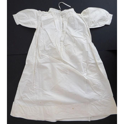 855 - A circa 1950s baby's nightgown; ivory-coloured cotton, gathered front with sash ties, long sleeves a... 