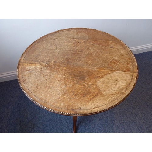 886 - An early 19th century circular oak and dog tooth banded tilt-top occasional table; turned stem with ... 