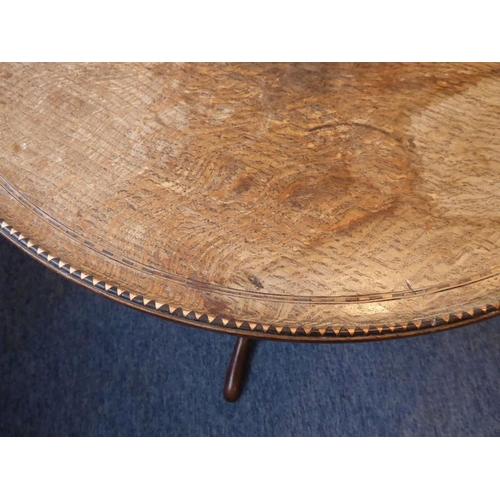 886 - An early 19th century circular oak and dog tooth banded tilt-top occasional table; turned stem with ... 