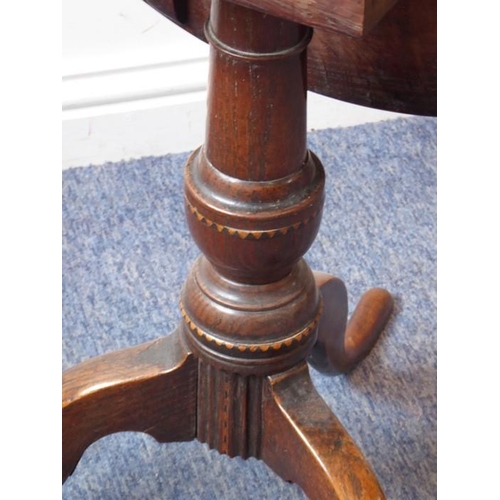 886 - An early 19th century circular oak and dog tooth banded tilt-top occasional table; turned stem with ... 