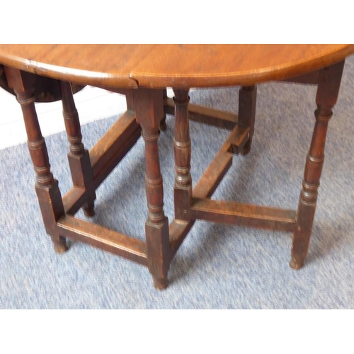 891 - An antique oak drop leaf gate leg table of small proportions; the oval top mounted on a (probably) 1... 