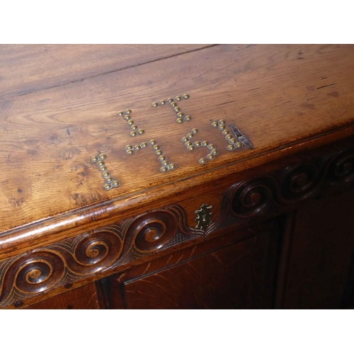 899 - A mid-18th century oak mule chest; the two-plank, cleated top studded with the initials I T and date... 