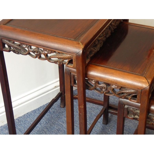 917 - A nest of four early 20th century Chinese carved hardwood occasional tables, the pierced friezes car... 