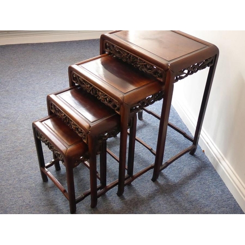 917 - A nest of four early 20th century Chinese carved hardwood occasional tables, the pierced friezes car... 