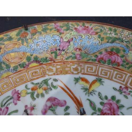 92 - A 19th century Chinese Canton porcelain charger; hand-decorated in the famille rose palette; the bor... 