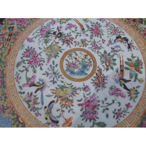 92 - A 19th century Chinese Canton porcelain charger; hand-decorated in the famille rose palette; the bor... 