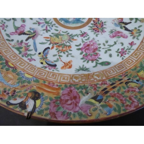 92 - A 19th century Chinese Canton porcelain charger; hand-decorated in the famille rose palette; the bor... 